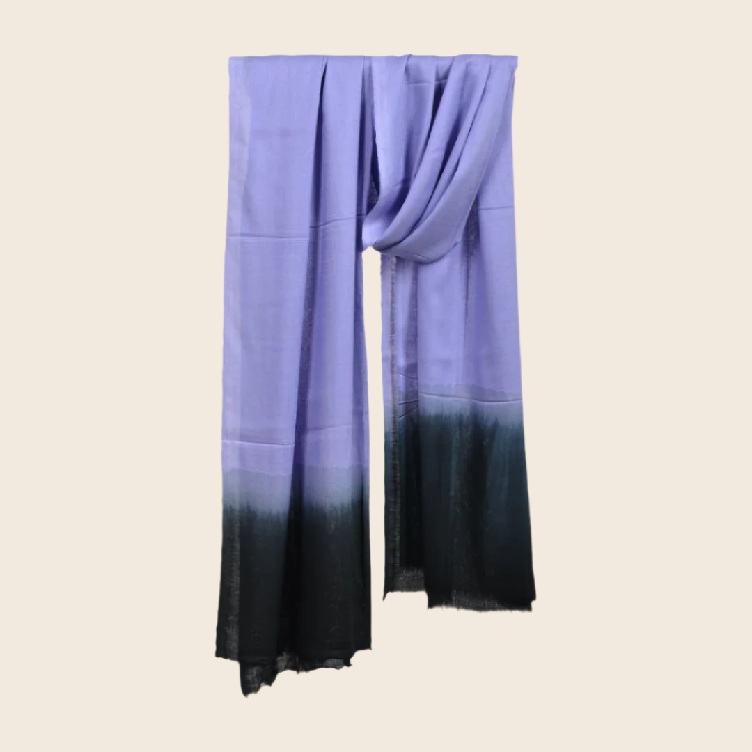 Vista Blue Soaked Tagelmust scarf – soft lavender‑blue hanging wrap fading to deep charcoal black gradient. Sustainably sourced lightweight Moroccan headscarf perfect for nomadic travelers searching for lavender, light‑blue, or black scarves for hot‑weather, dry‑climate adventures